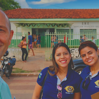 capa - para cego ver: alunas de gestão pública, Karen Silva e Samira Borges, junto ao orientador, Luiz Carlos, ao fundo a escola vizinha ao campus, Ednilson Francisco Kolling
